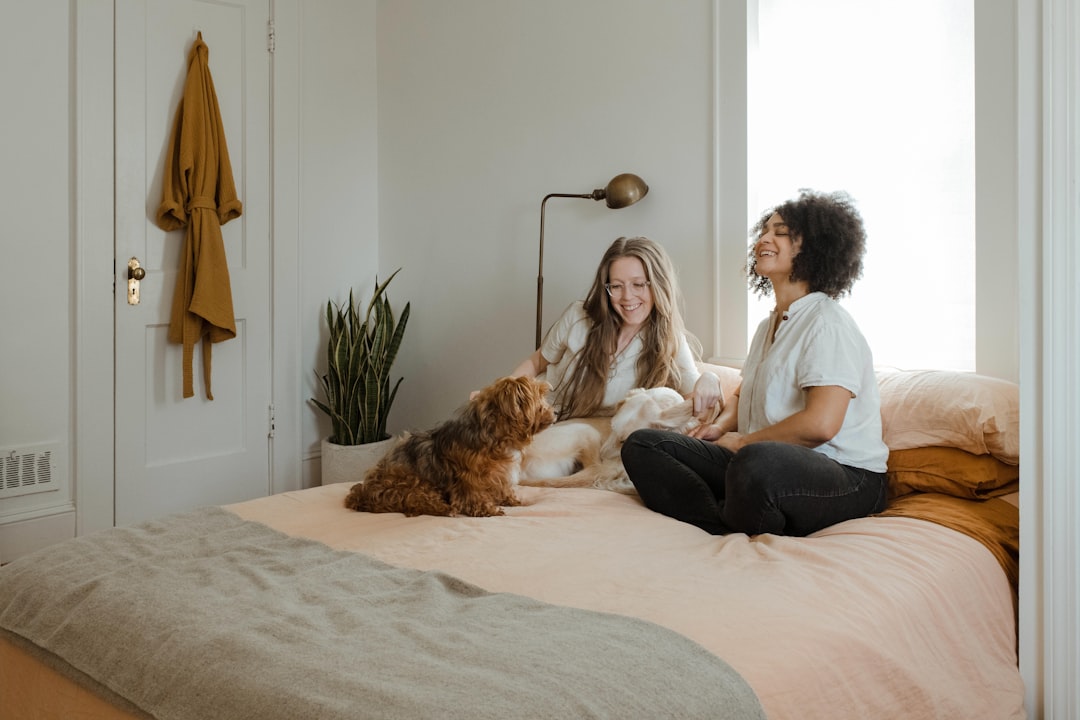 A cozy living room with a vacuum cleaner, pet toys, and a cat and dog playing together, showcasing a clean and pet-friendly environment.